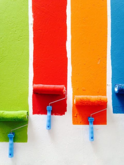Væg der er malet med fire forskellige malerruller i hver sin farve
